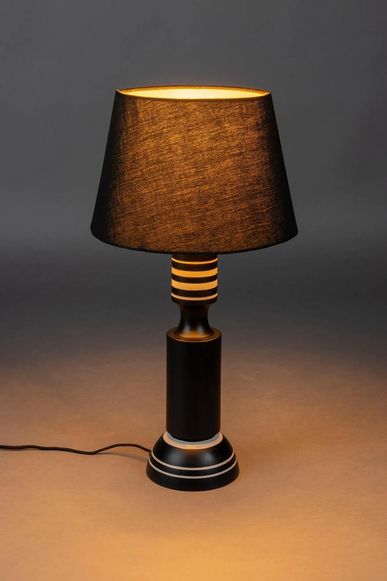 Die Tischlampe Virgil von Dutchbone vereint 50er-Jahre-Design mit modernem Flair: Eisenfuß, Leinenlampenschirm, stilvoll und funktional.