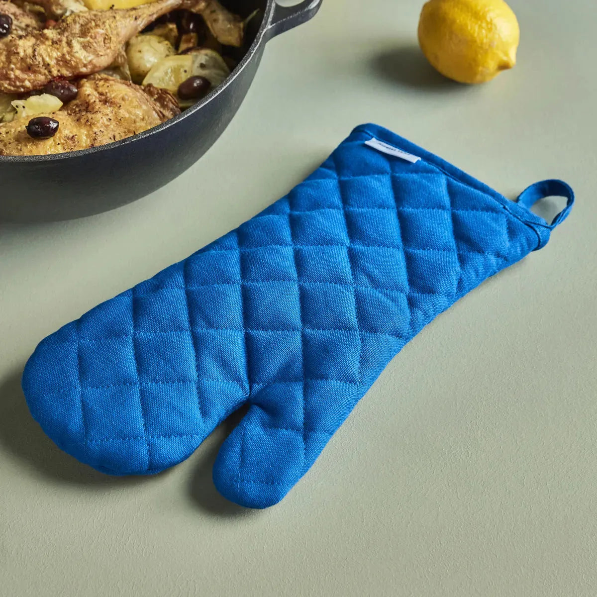 Eleganter blauer Küchenhandschuh von Nicolas Vahé für sicheres Kochen.