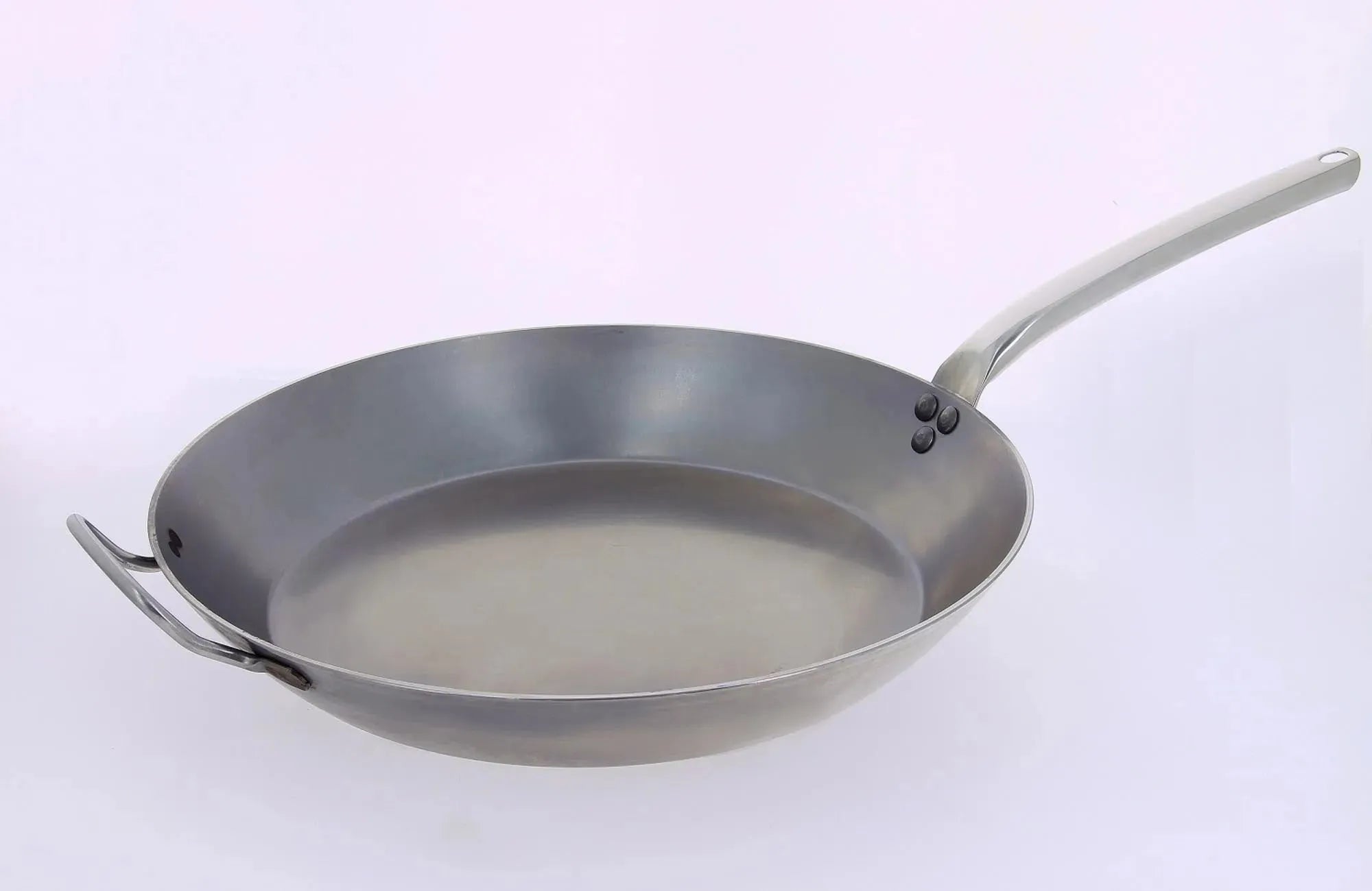 Die CARBONE PLUS Bratpfanne Ø 24cm von de Buyer: robustes Stahlblech, ergonomischer Edelstahlgriff, ideal für Induktion, langlebig und pflegeleicht.