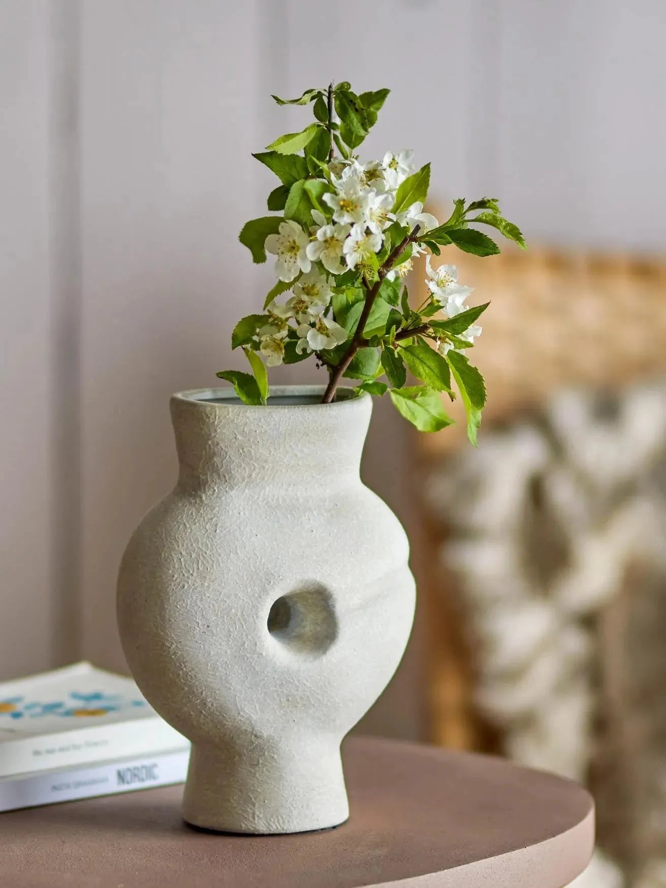 Die Chania Deko-Vase aus Terrakotta von Bloomingville besticht durch ihr markantes Design mit Loch, ideal für Trockenblumen.