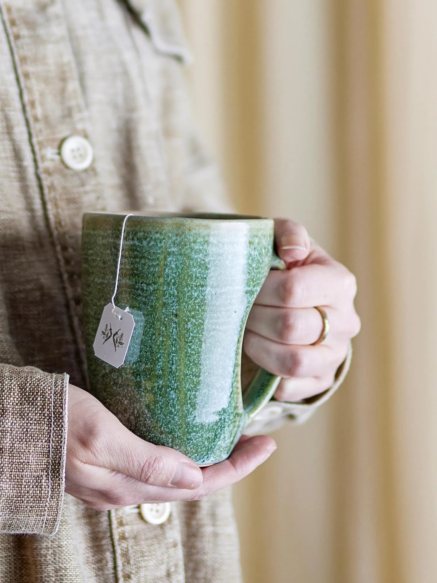 Der Aura Becher in Grün von Bloomingville vereint skandinavische Eleganz mit robuster Steingutqualität und einzigartiger Glasur.