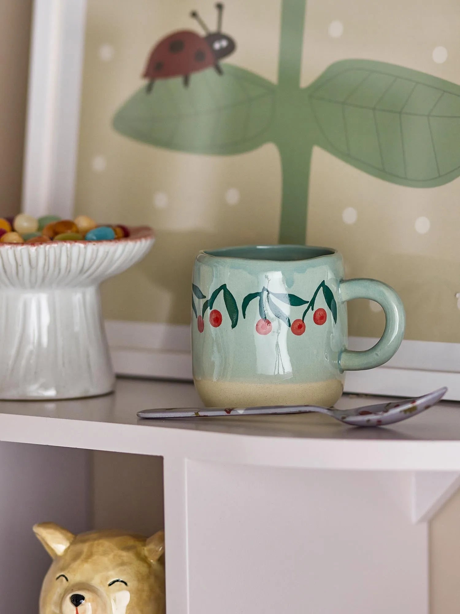 Die Millie Tasse in sanftem Blau mit Kirschmuster ist ein charmantes Steingutstück für Kinder und Junggebliebene.