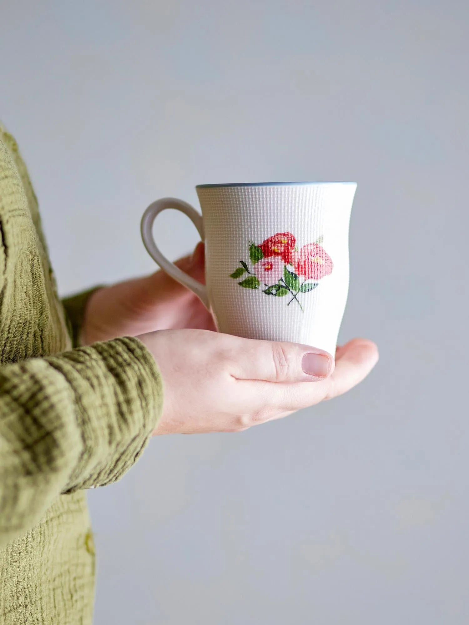 Eleganter Becher aus Steingut mit floralem Design, ideal für heiße Getränke. Spülmaschinen- und mikrowellengeeignet.