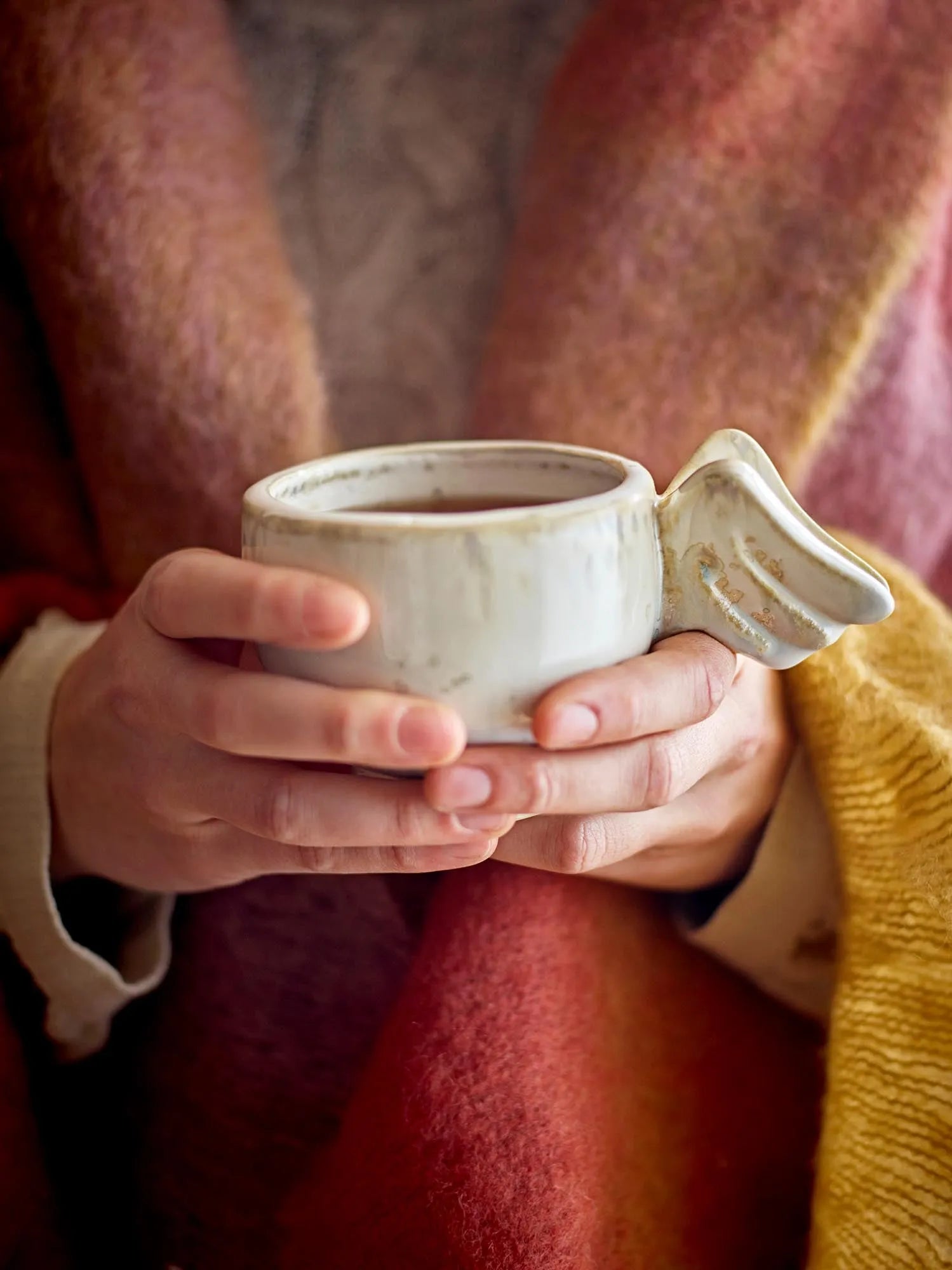 Die Seraphine Tasse von Bloomingville: Einzigartige Steingut-Tasse mit reaktiver Glasur und Engelsflügel-Griff in Naturtönen.