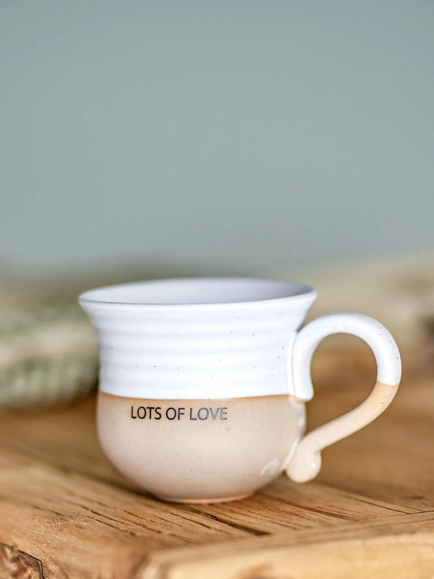 Elegante Claire Tasse aus weißem Steingut mit "Lots of love"-Schriftzug, robust und spülmaschinenfest.