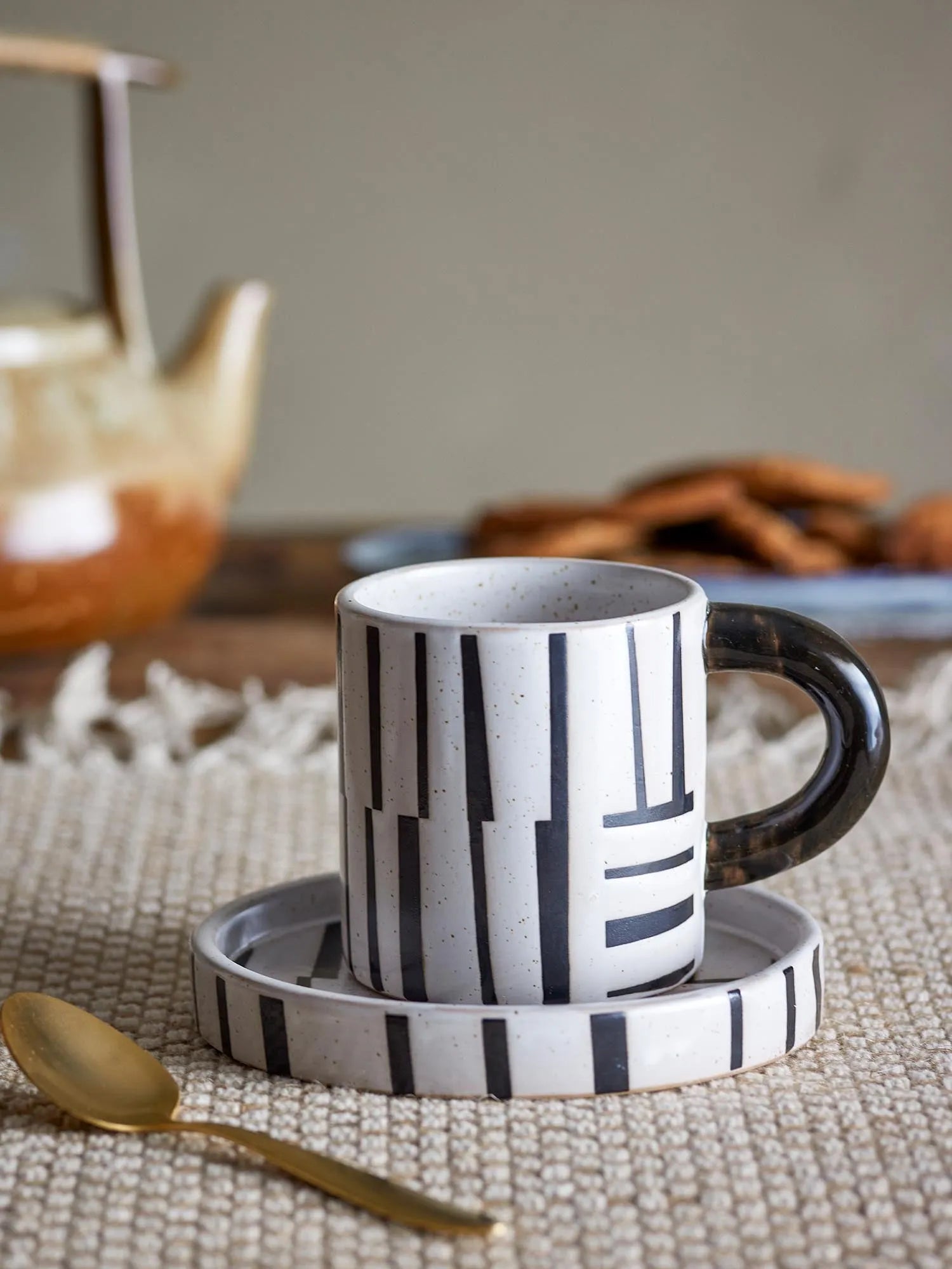 Elegante schwarze Tasse mit Untertasse aus Steingut, vereint skandinavisches Design und Funktionalität. Perfekt für stilvolle Momente.