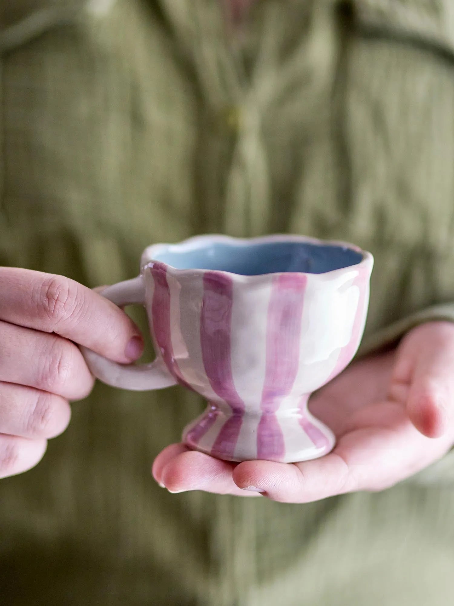 Die Willa Tasse in zartem Rosa, aus robustem Steingut, vereint Eleganz und Funktionalität mit handbemalten Streifen.