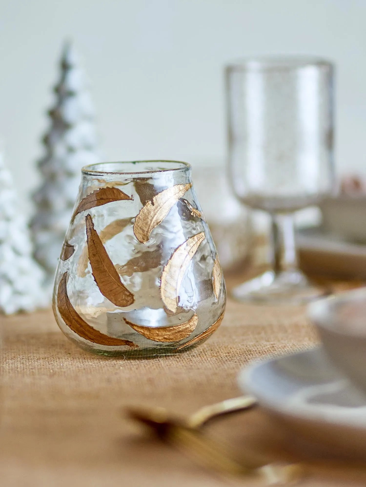 Eleganter Teelichthalter aus recyceltem Glas mit goldenen Blättern, der Licht und Nachhaltigkeit vereint.