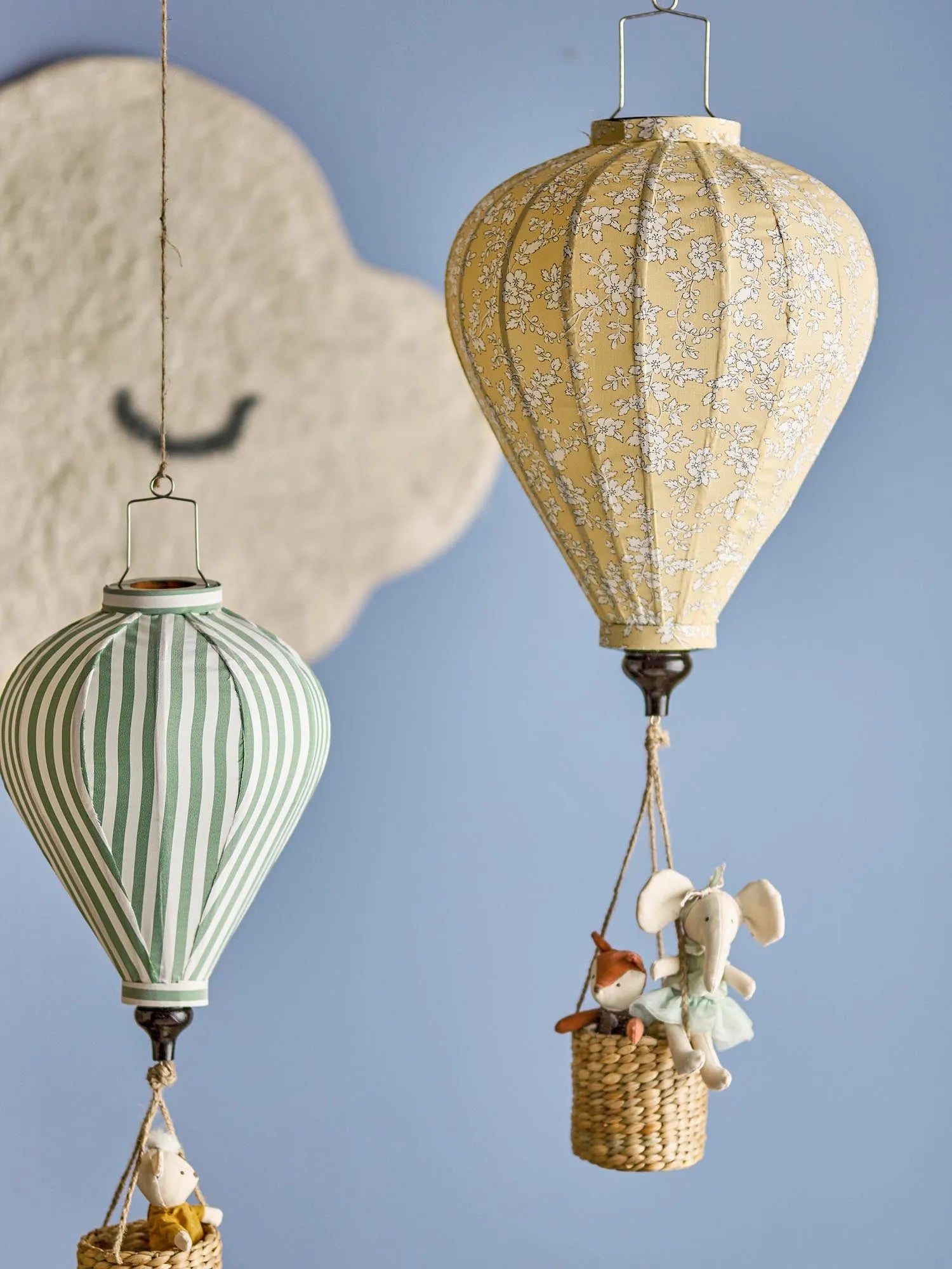 Ein zauberhaftes, gelbes Heißluftballon-Mobile mit Blumenmuster und Lichterkette, ideal für das Kinderzimmer.