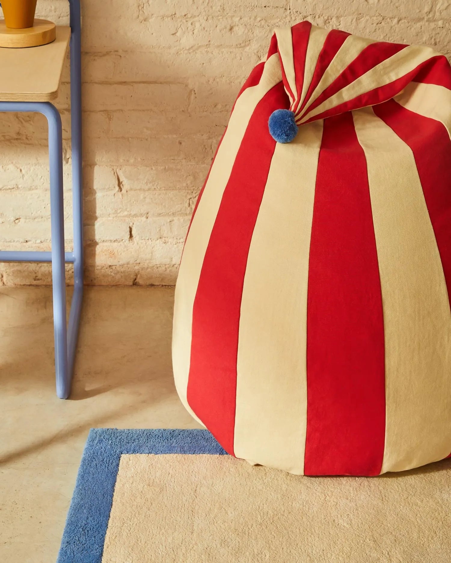 Der Olvi Sitzsack in Rot-Beige mit blauer Quaste ist ein stilvolles, bequemes Möbelstück aus Baumwolle für jeden Raum.