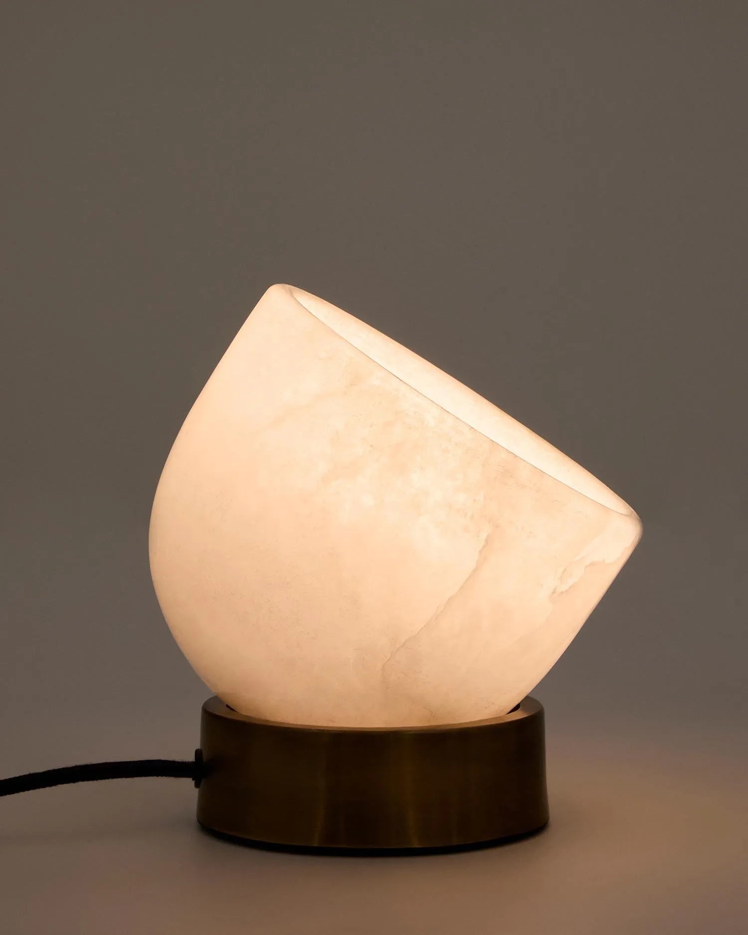 Die Tischleuchte Shenli vereint Alabaster und Messing für sanftes Licht und stilvolle Eleganz, ideal für jeden Raum.