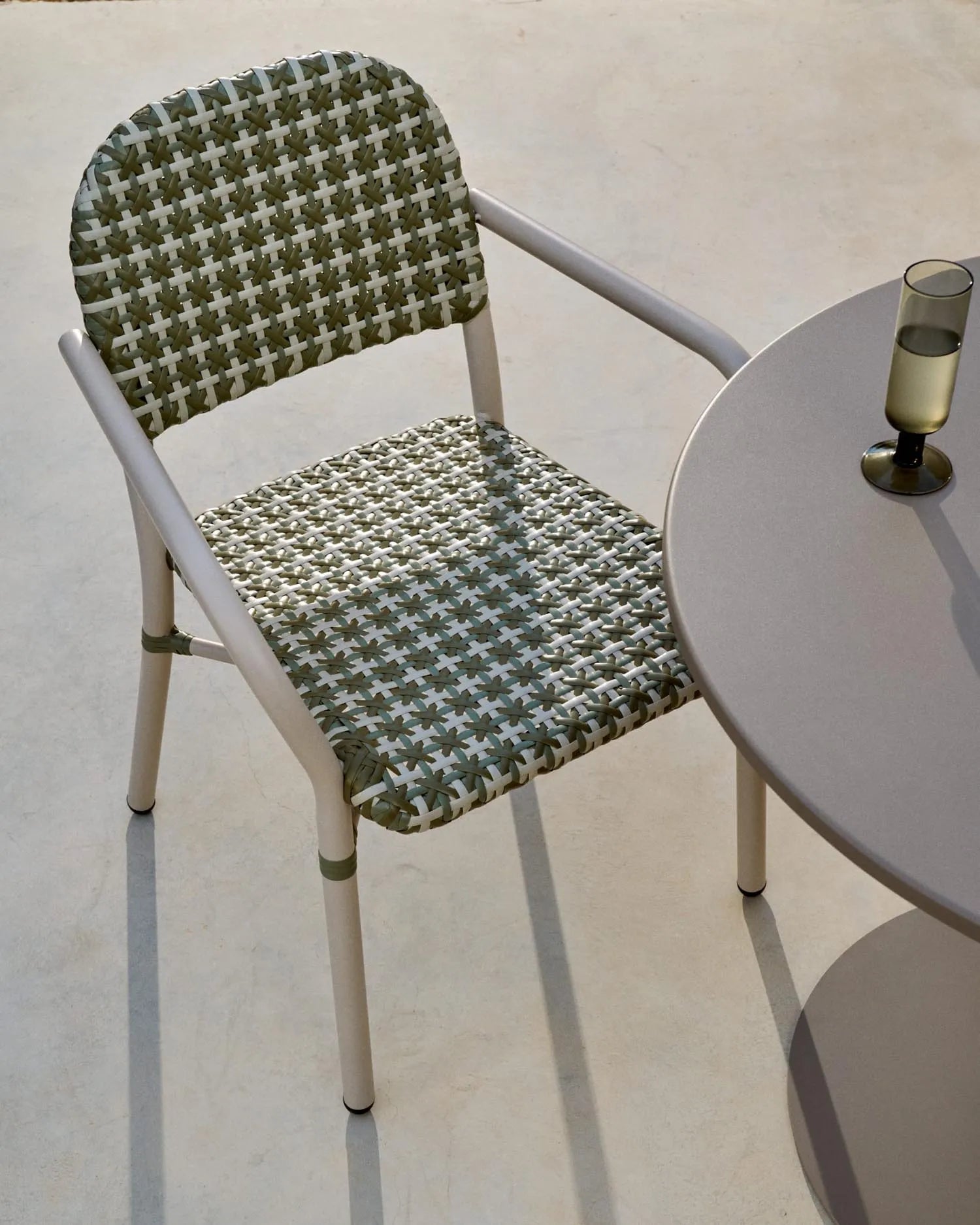 Eleganter, stapelbarer Bistrostuhl aus Aluminium und Kunstrattan in Beige-Grün, ideal für flexible, stilvolle Außenbereiche.