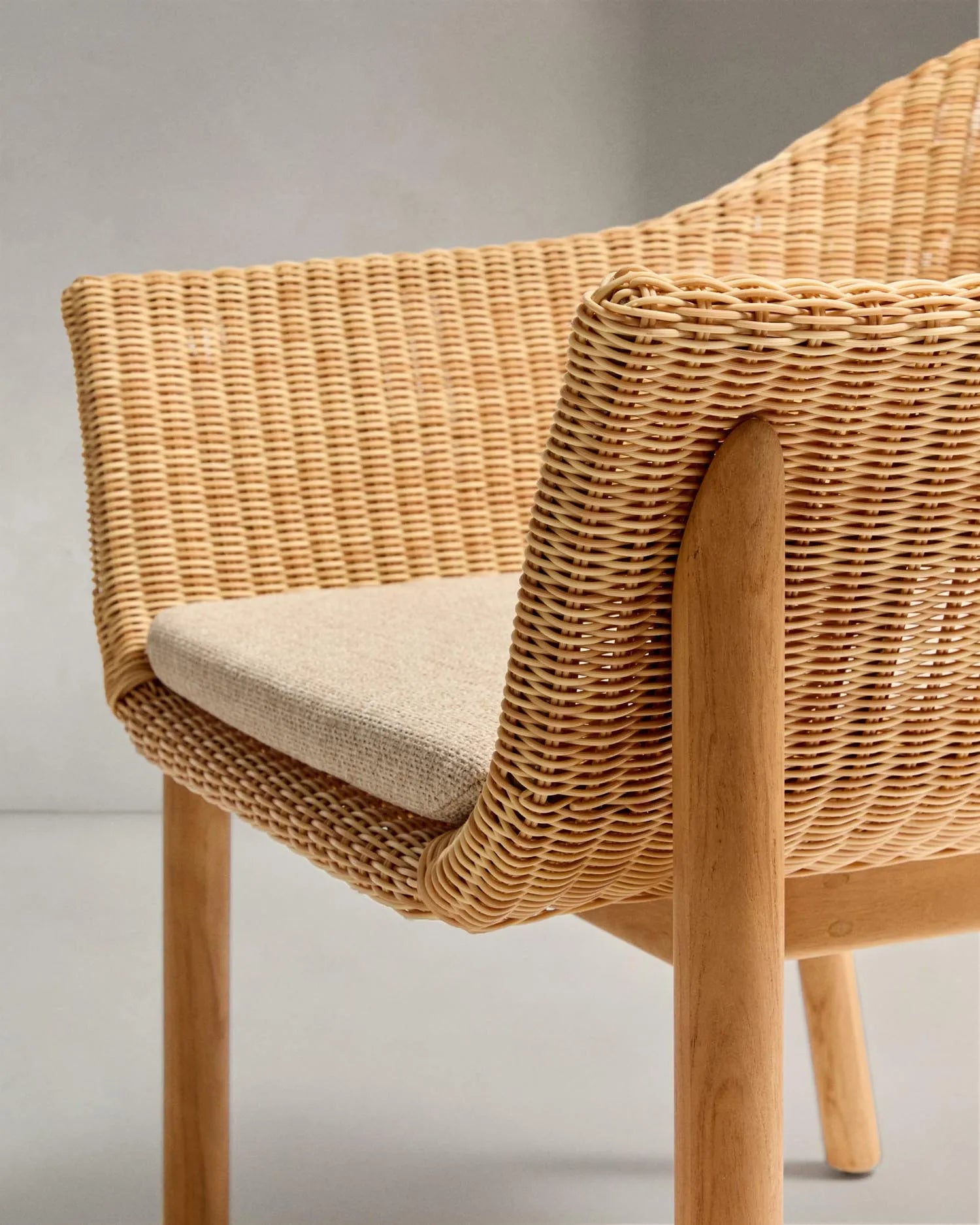 Der Stuhl Galea vereint robustes Teakholz mit elegantem, pflegeleichtem Rattan für stilvollen Komfort im Freien.