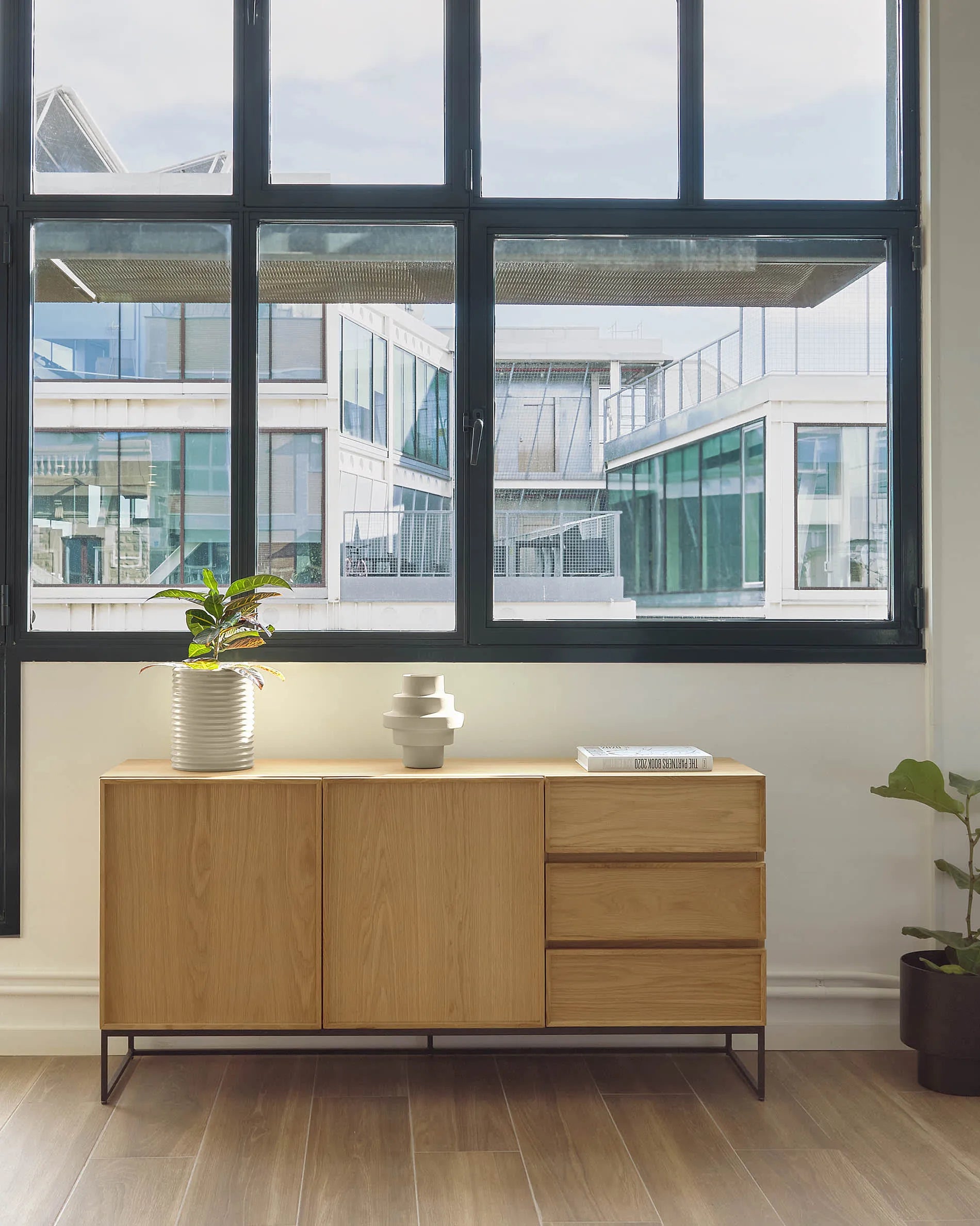 Elegantes Sideboard mit Eichenfurnier und schwarzem Stahlgestell, bietet viel Stauraum und passt in moderne Wohnräume.