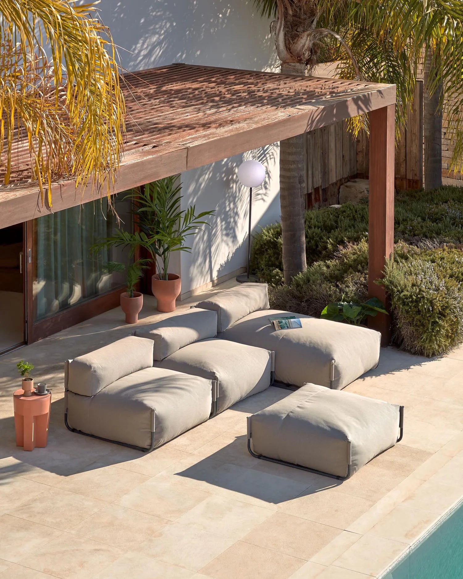 Elegantes, wetterfestes Pouf-Sofa in Grün mit schwarzem Aluminiumgestell, ideal für flexible Outdoor-Lounges.